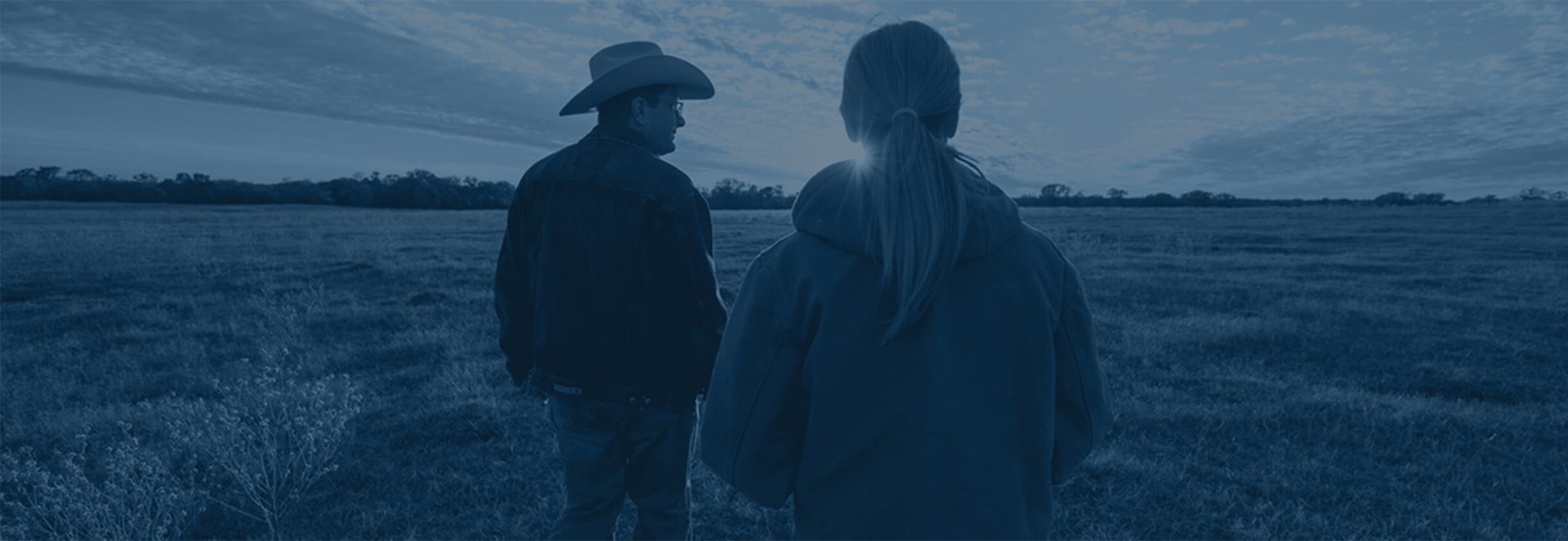 Farmer and wife in field at sunset